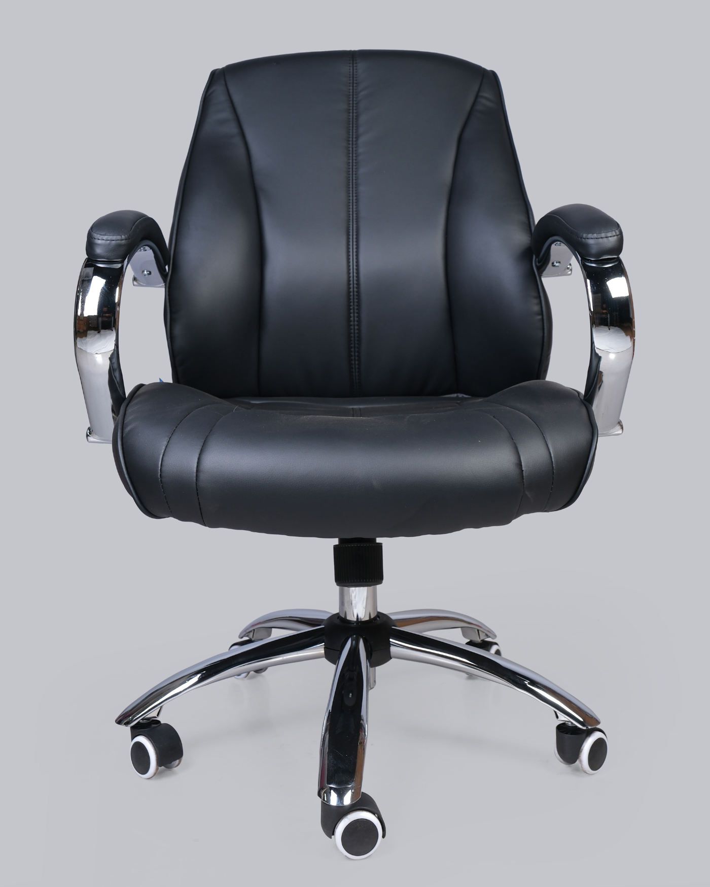 Black office chair with chrome base on a gray background